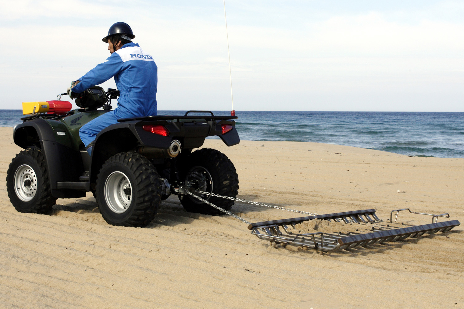 ATVでビーチクリーナーをけん引している様子