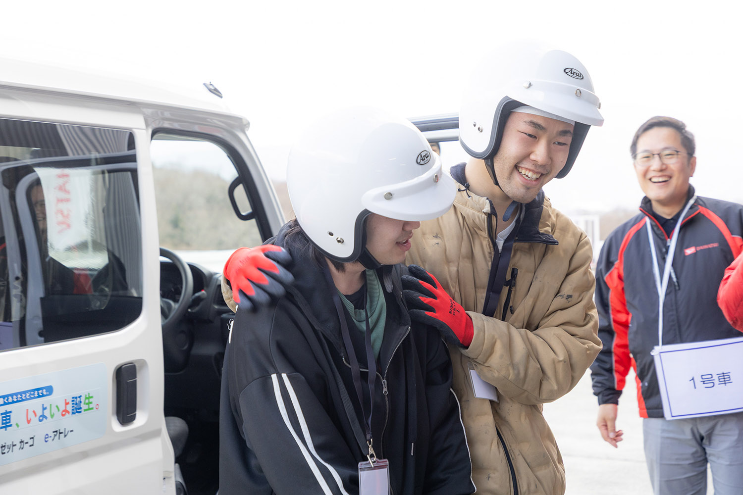 ダイハツ車に乗って笑顔になる学生たち