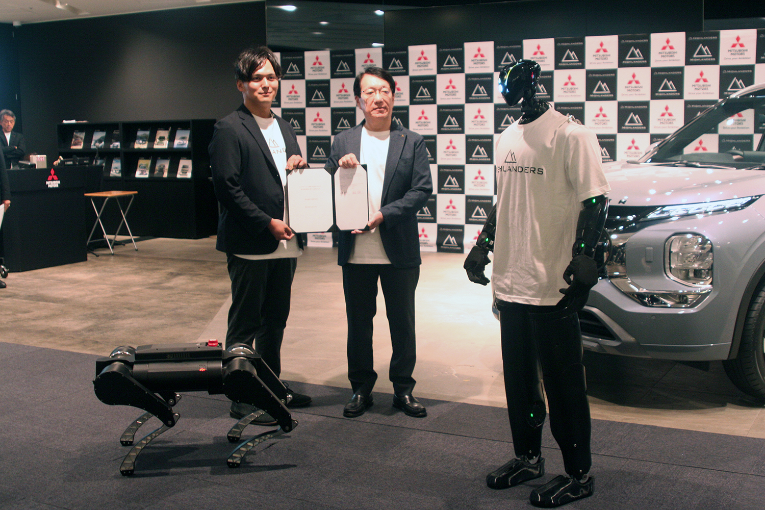 フィジカルAIに関する基本合意を締結したハイランダーズの増岡CEOと三菱自の加藤CEOとヒューマノイド「N」