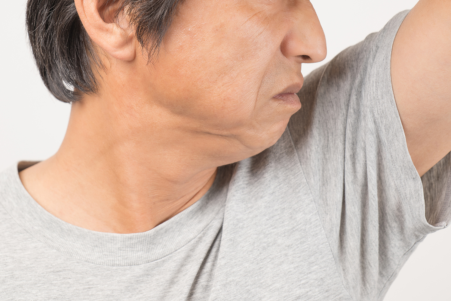 ワキの臭いを確認する男性