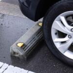 駐車場の「車止め」にタイヤを当てるべきじゃない？　クルマが傷むとの噂の真相とは