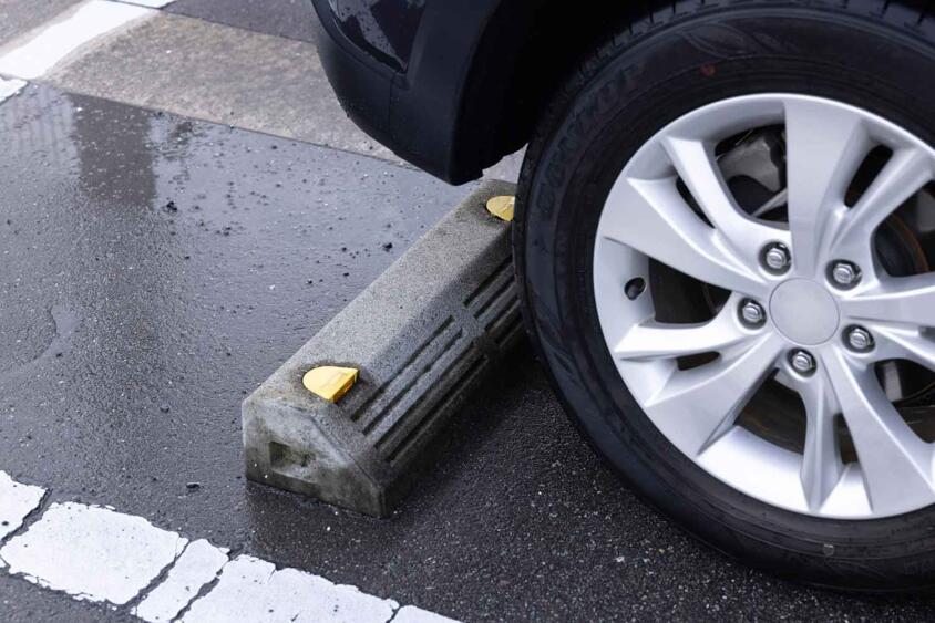 駐車場の「車止め」にタイヤを当てるべきじゃない？　クルマが傷むとの噂の真相とは