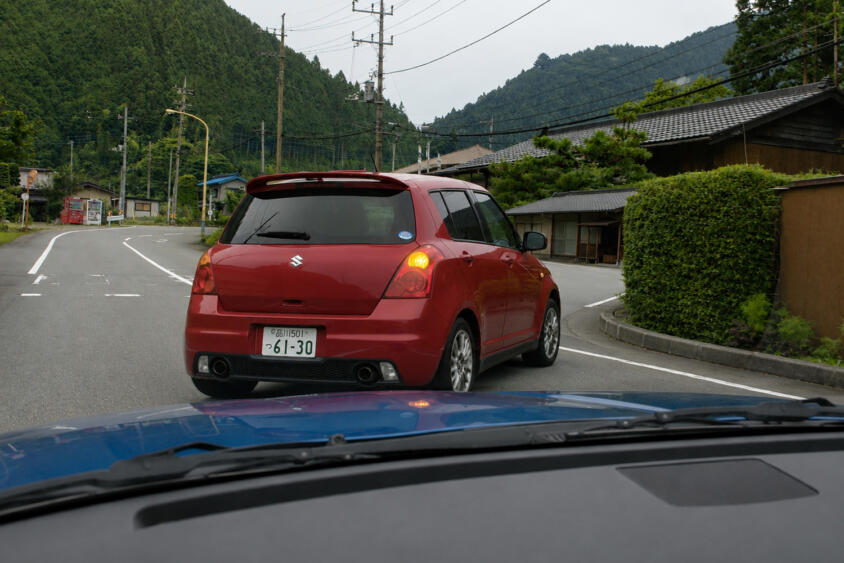 片側１車線道路で前のクルマが右折待ち！　寄ればギリギリ左側を抜けて直進できそうだけどこれって合法？