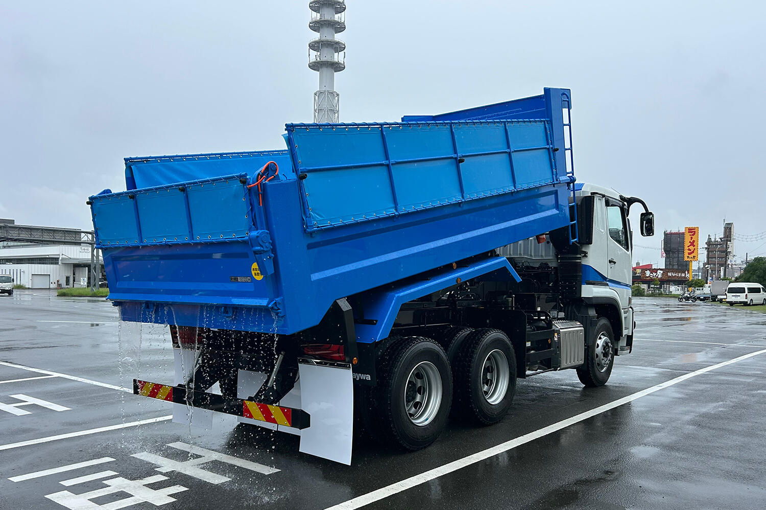 荷台を傾けたダンプカーのイメージ