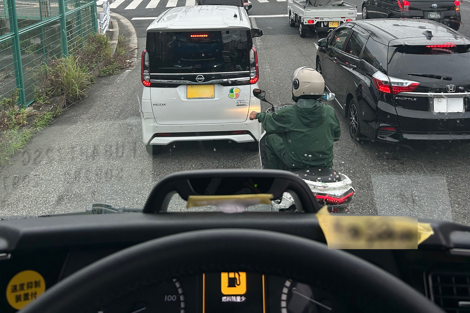 信号待ちをする原付バイク